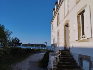 a building with stairs leading up to a building at studio moderne les pieds dans l'eau in Larmor-Baden
