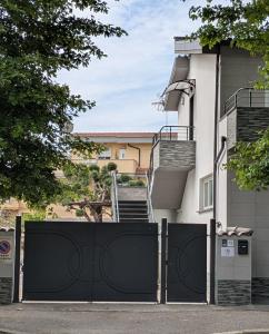 a black gate in front of a house with stairs at AURA MARINA - Guest House Fiumicino in Fiumicino