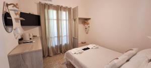 a small white room with a bed and a window at Pension Hara in Patitiri