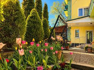 a garden with pink flowers in front of a house at Hotel Jasmin All Inclusive in Truskavets