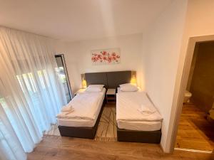 a room with two beds and a window at Domus Klek in Kučinić-Selo