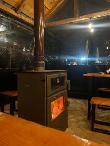 a wood stove in a restaurant with a table and a table at Guesthouse Kujtimi in Theth +86 photos