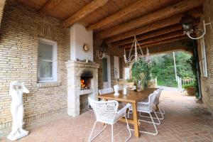 a patio with a table and chairs and a fireplace at Guesthouse Thomas in Vátos