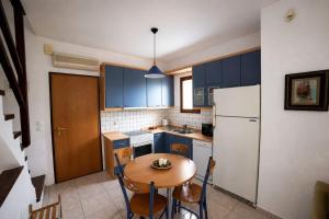 a kitchen with a table and a white refrigerator at Perfect House in Pefkochori