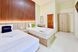 a bedroom with two beds and a window at Urbanview Hotel MD Residence in Sunggal