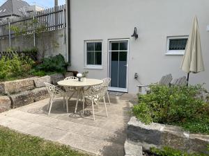 a patio with a table and chairs and an umbrella at Ferienwohnung am Storchennest in Ichenhausen