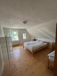 a bedroom with two beds and a wooden floor at Ubytování NAPOLI in Stará Červená Voda