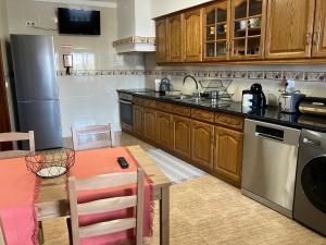 a kitchen with wooden cabinets and a table with a tableablish at Alojamentos Vila Alpalhão in Alpalhão