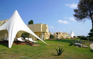 a white tent sitting on a grass field at Hotiday Torre Santo Stefano Resort in Otranto