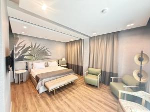 a bedroom with a bed and a couch and a chair at Duman Boutique Hotel in Mamaia +40 photos