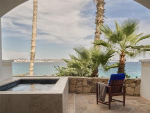 a chair sitting in front of a pool with the ocean at One&Only Palmilla in San José del Cabo