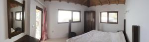 a bedroom with a bed and two windows at Sabri's Penthouse in Ogled