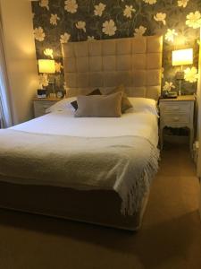 a bedroom with a large white bed with two night stands at Castle Lodge Hotel in Ross on Wye