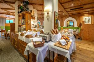 a restaurant with white tables and baskets of bread at Natur & Alpinhotel Post in Vent