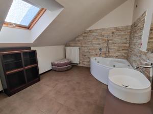 a attic bathroom with a tub and a sink at Riflessi sul lago Lierna bed and breakfast in Lierna