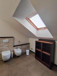 a bathroom with a skylight and a toilet and a sink at Riflessi sul lago Lierna bed and breakfast in Lierna