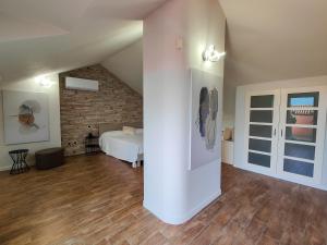 a large room with a bed and a brick wall at Riflessi sul lago Lierna bed and breakfast in Lierna +12 photos