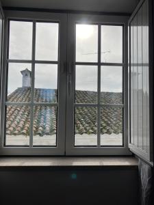 two windows in a room with a view of a building at Alojamentos Vila Alpalhão in Alpalhão
