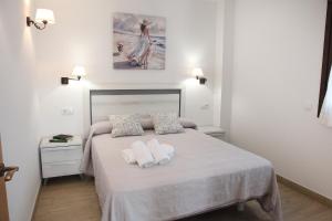 a bedroom with a bed with two towels on it at Apartamentos Los Novalejos in Arnuero