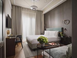 ein Hotelzimmer mit zwei Betten und einem Tisch in der Unterkunft ON Residence - Small Luxury Hotels of the World in Thessaloniki