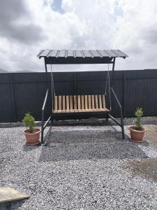 a swing with two potted plants and a fence at APARAN House in Aparan