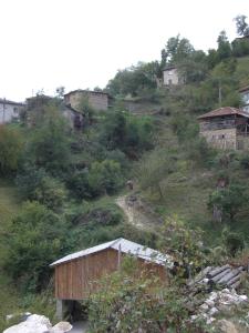 a small building on a hill with houses on it at Sabri's Penthouse in Ogled +3 photos