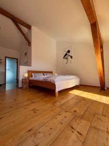 a bedroom with a bed and a wooden floor at Ferienwohnung Bergblick in Bad Aibling