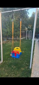 a toy swing in a field of grass at Wooden Guest House in Bamatat