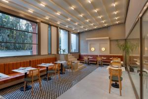 a restaurant with tables and chairs and windows at Mesona Hotels Blue Hill in Antalya