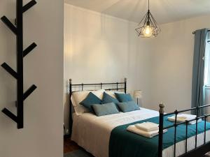 a bedroom with a bed with blue pillows at Alojamentos Vila Alpalhão in Alpalhão
