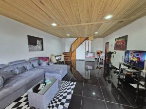 a living room with a couch and a tv at Hostel Sao Gabriel - new pool in São Tomé