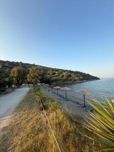 a beach with umbrellas and chairs and the water at Kamares Bay Escape in Gythio