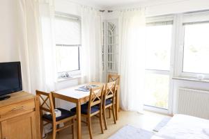 a dining room with a table and chairs and windows at Strandnahe Ferienwohnung mit Privatweg, Spielplatz & Aufzug in Sankt Peter-Ording +25 photos