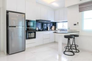 a kitchen with a stainless steel refrigerator and a counter at Indiluxe pool villa in Pattaya South