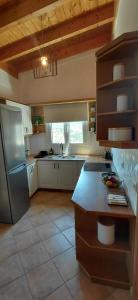 a kitchen with a stainless steel refrigerator and a sink at Sea & Sun Ikaria in Gialiskari