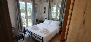 a bedroom with a white bed with towels on it at Sea & Sun Ikaria in Gialiskari