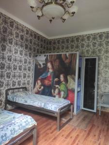 a room with two beds and a painting on the wall at сой333 in Navoi