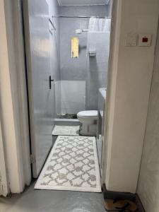 a small bathroom with a toilet and a shower at Platinum House in Nyeri +4 photos