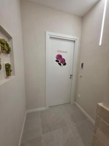 a white hallway with a door with a sign that reads orchestration at Flag in Torre del Greco