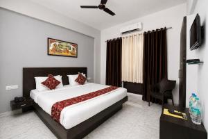 a hotel room with a bed and a chair at Hotel Ace Plaza in Udaipur +20 photos