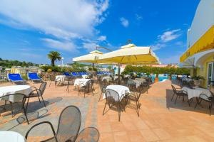 an outdoor patio with tables and chairs and umbrellas at Hotel Terme Felix in Ischia Town