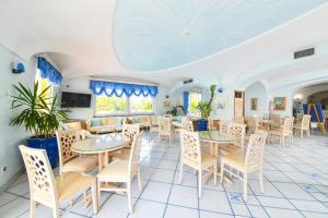 a restaurant with tables and chairs and a couch at Hotel Terme Felix in Ischia Town
