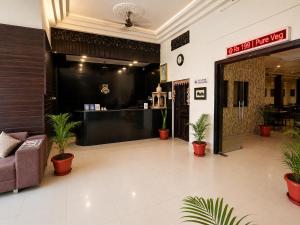 a lobby with a waiting area with potted plants at Hotel Ace Plaza in Udaipur