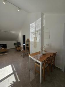 ein Wohnzimmer mit einem Holztisch und Stühlen in der Unterkunft הסוויטה בטיילת in Aschdod