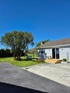 ein Haus mit einem Picknicktisch und einem Baum in der Unterkunft Vimy House in Clifden
