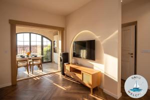 a living room with a tv and a dining room at NAVU Apartment in Katun