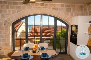 a dining room with a table and chairs and a large window at NAVU Apartment in Katun