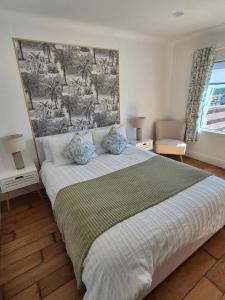 ein Schlafzimmer mit einem Bett und einem großen Gemälde an der Wand in der Unterkunft Vimy House in Clifden