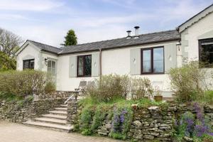 a white house with a stone wall at 1 Bed in Llanerchymedd oc-wai212 in Llanerchymedd