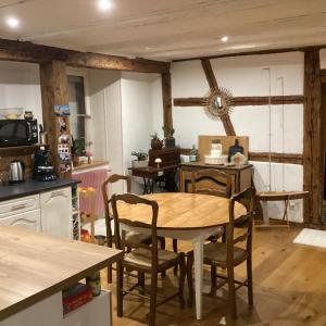 a kitchen with a wooden table and chairs at Vincenzo le cyclo in Kientzheim